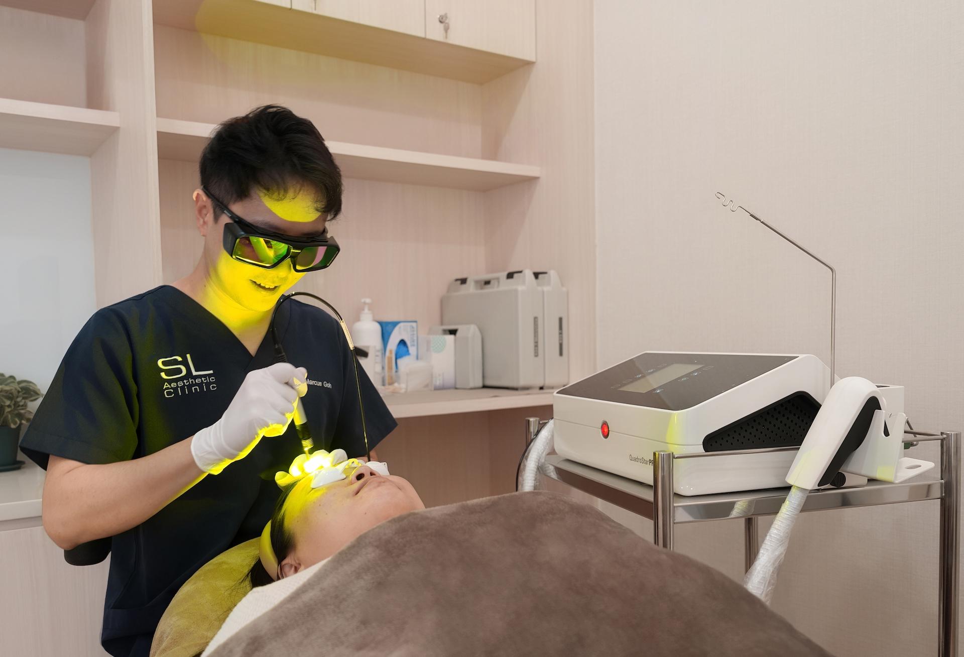 Patient undergoing Pro Yellow Laser facial treatment with a clinician using a yellow laser device to treat the skin.