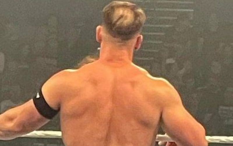 Back view of John Cena in a wrestling ring, with noticeable thinning hair at the crown of his head.