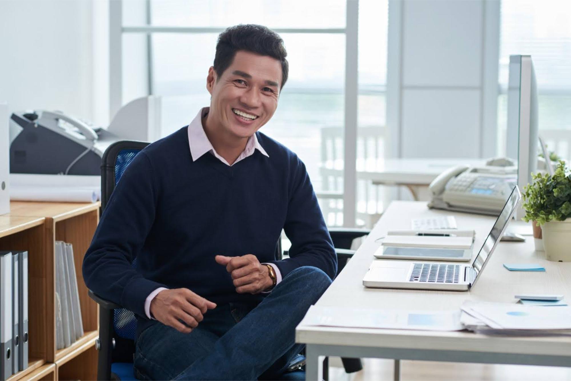 Smiling employee sitting at a desk in his office